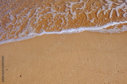 Sand beach with white sea soft foam wave on top view in thailand for assembling an article about travel in summer holiday or ocean sand beach coast nature.