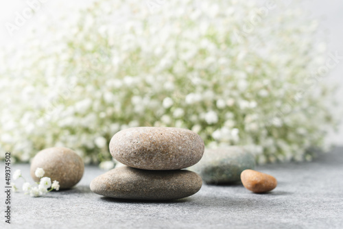 Cosmetic podium made of stones with flowers in the background. Natural background for product presentation