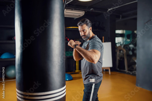 Young sportsman boxing workout at the gym, guy punching the boxing bag © Ramzi