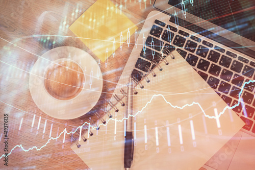 Double exposure of forex chart drawing over table background with computer. Concept of financial research and analysis. Top view.