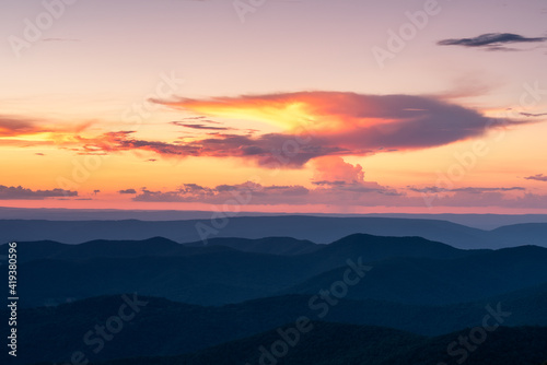 A storm cloud's "anvil' catches fire in sunset light over Shenandoah National Park during the Summer.