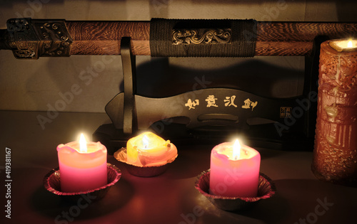 Shaolin sword lit by candlelight in a dark room