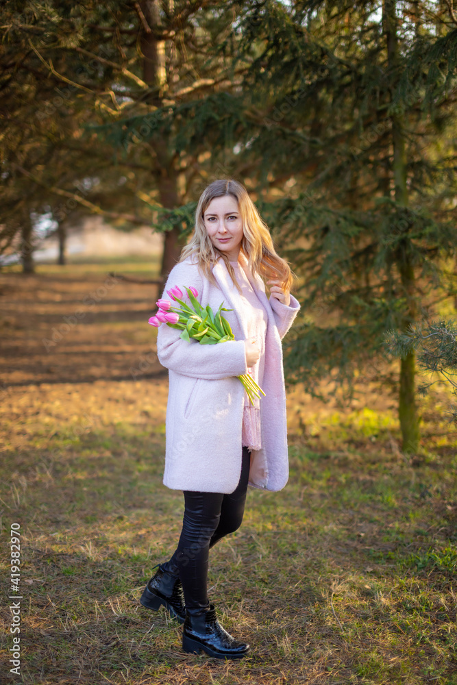 Young woman with a bouquet of tulips at the park, spring nature in Europe Young woman with a bouquet of tulips at the park, spring nature in Europe