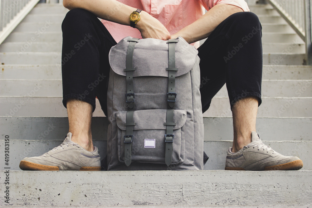 A man sitting with a backpack - obrazy, fototapety, plakaty 