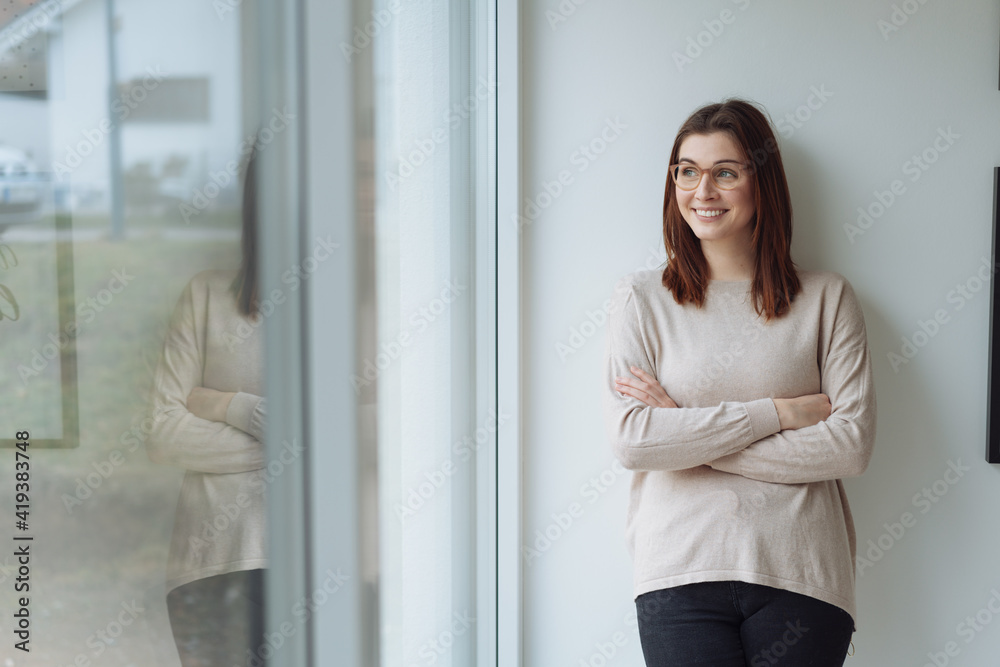 Young woman enjoying happy memories looking out of a window