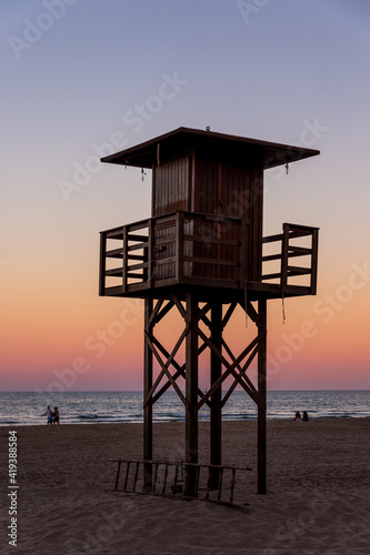 wooden Lifeguard Tower at the beach with sunset lightning
