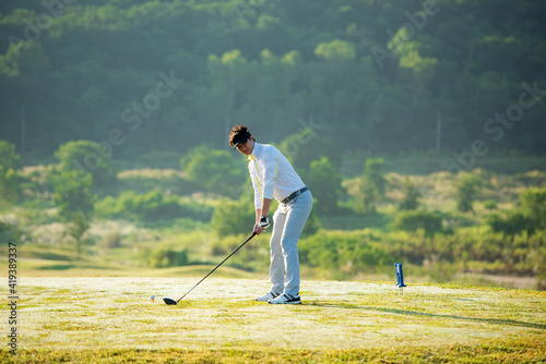 Golfer sport course golf ball fairway. People lifestyle man approach playing game golf tee off on the green grass.  Asian man player game shot in summer. 