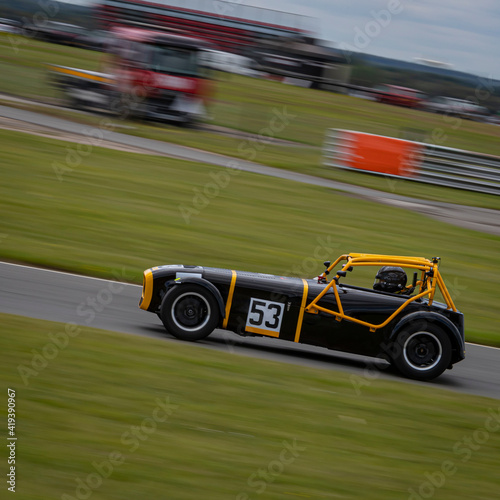 A panning shot of a racing car as it circuits a track. © SnapstitchPhoto