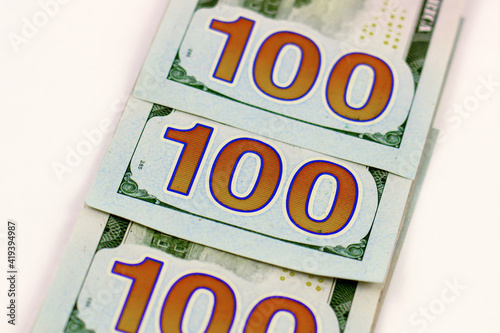 three hundred dollar bills lie on a light background, close-up