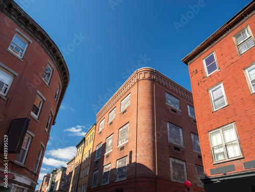 Three red brick retro-style buildings on blue sky background
