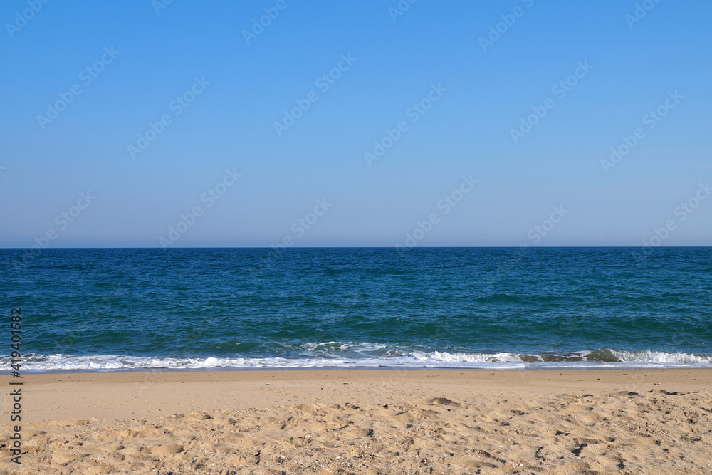 empty sandy beach, sea horizon and clear sky