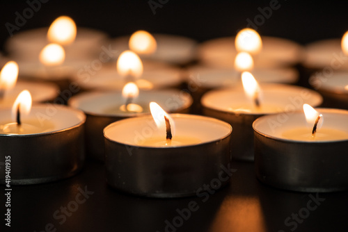 candles burning at night.Many candle flames glowing on dark background