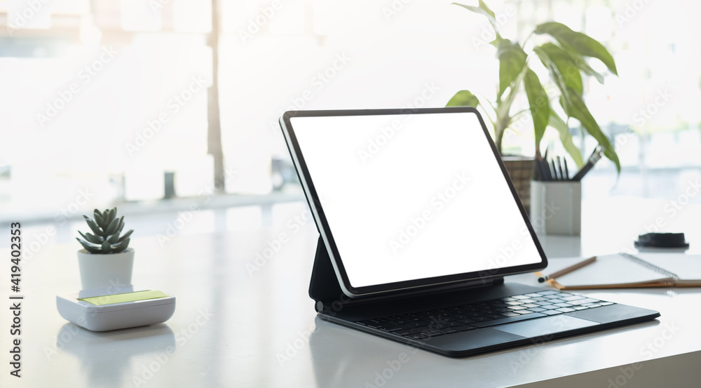 Cropped shot of workplace with tablet blank screen and office supplies in simple workspace. Cropped shot of workplace with tablet blank screen and office supplies in simple workspace.