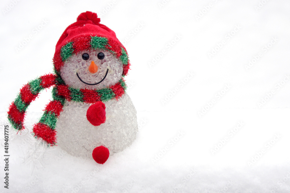 cute snowman ornament on white snow background and copy space