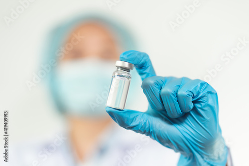 doctor or scientist in laboratory holding a Coronavirus Vaccine in glass bottle. Covid-19 corona virus treatment concept.