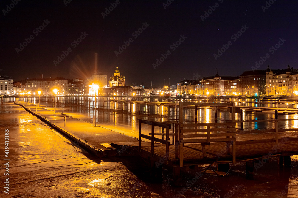 Finland, Helsinki, 03 March 2021. Night panorama of Helsinki, a view of the Katajanokka and Krununhakka districts in the foreground the Gulf of Finland and boat docks Finland, Helsinki, 03 March 2021. Night panorama of Helsinki, a view of the Katajanokka and Krununhakka districts in the foreground the Gulf of Finland and boat docks
