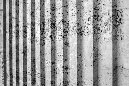 black and White vertical stripe plastered wall. old background with cracks and scuffs