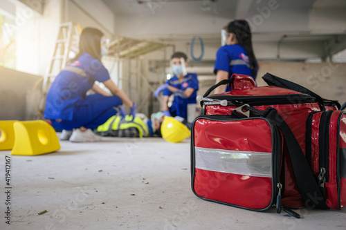 Selective focus is first aid bag. Team paramedic firs aid employee accident in construction site work. Emergency service. First aid procedure. photo