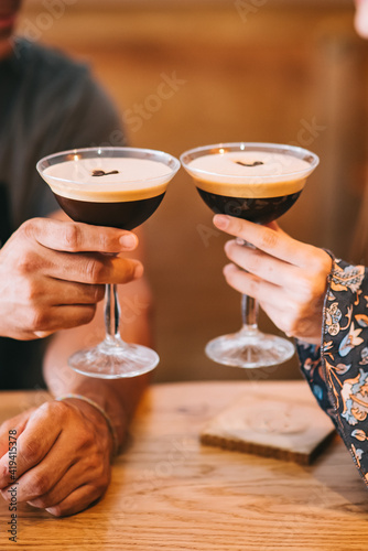 Two servings of espresso coffee cocktail in tall martini glasses decorated with coffee beans.