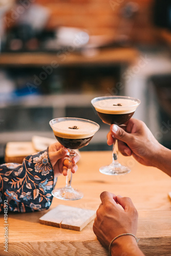 Two servings of espresso coffee cocktail in tall martini glasses decorated with coffee beans.