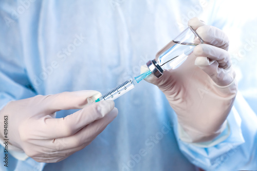 Influenza and coronavirus vaccination. Ddoctor or nurse holds syringe and medical injection in hands. Close-up.