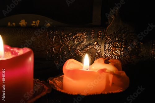 Candlelight illuminates the scabbard of an ancient Chinese sword with dragon