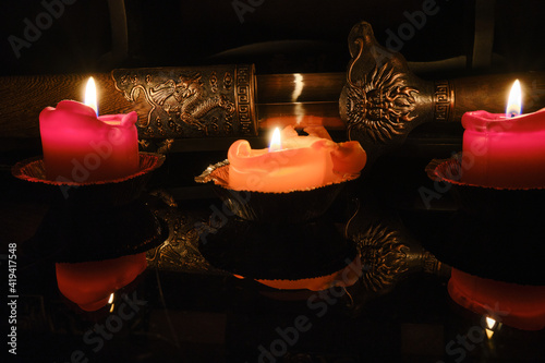 Candlelight illuminates the scabbard of an ancient Chinese sword with dragon