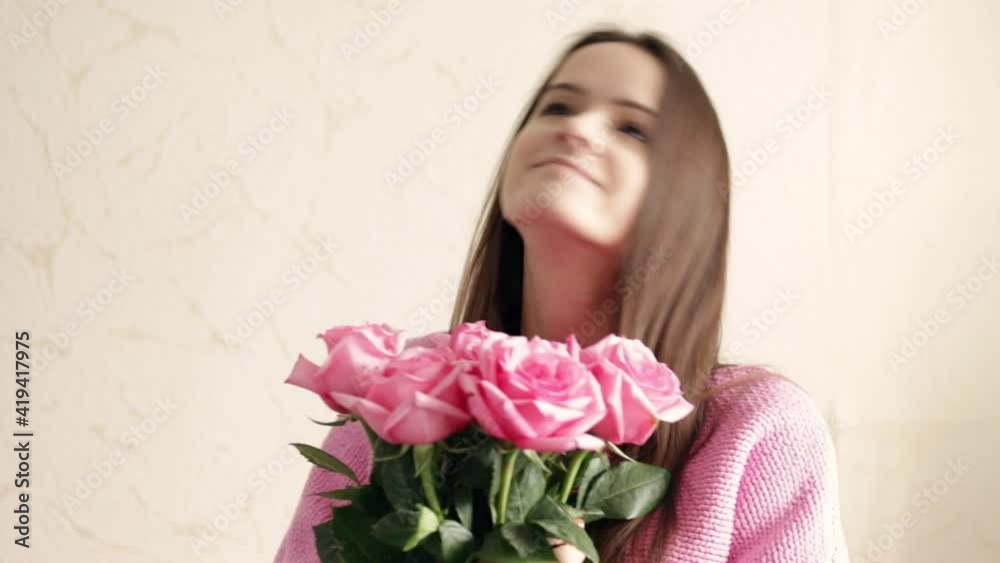 Young girl with a bouquet of flowers, receives pink roses Young girl with a bouquet of flowers, receives pink roses