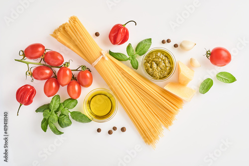 Spaghetti, fresh tomato, herbs and spices. Composition of healthy food ingredients isolated on white background, top view. Mock up.