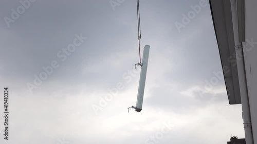 5G antenna being lifted by a crane to be installed on top of a building