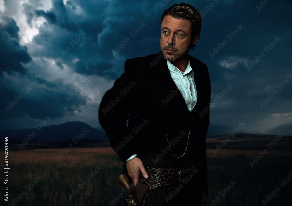 Man in victorian clothing with revolver in holster standing on prairie area. Man in victorian clothing with revolver in holster standing on prairie area.