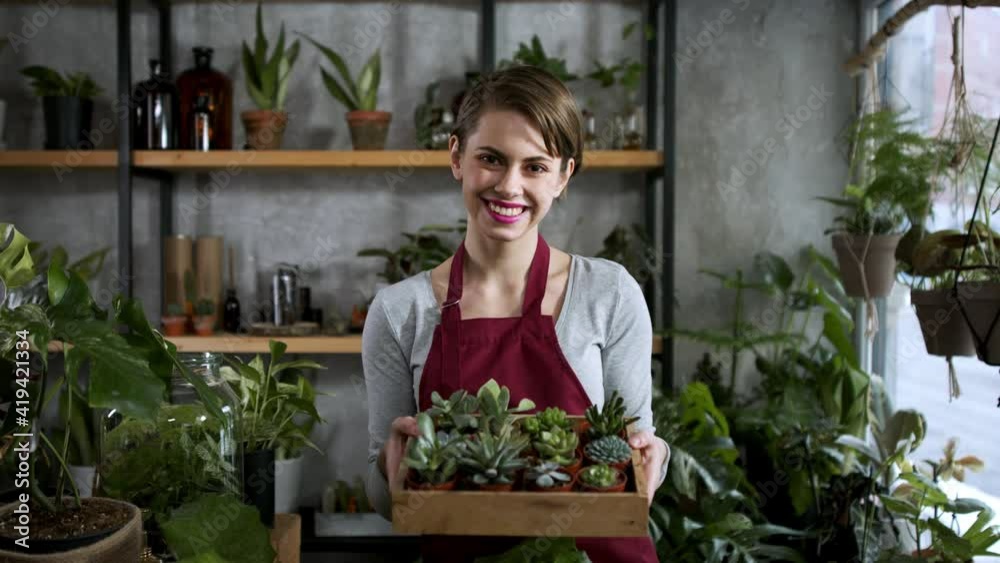 Shop assistant working in indoor potted plant store, small business concept. Shop assistant working in indoor potted plant store, small business concept.