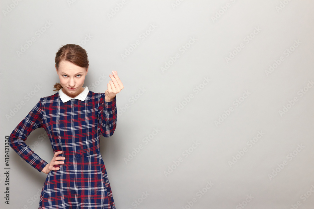 Portrait of serious discerning girl making money gesture with fingers Portrait of serious discerning girl making money gesture with fingers