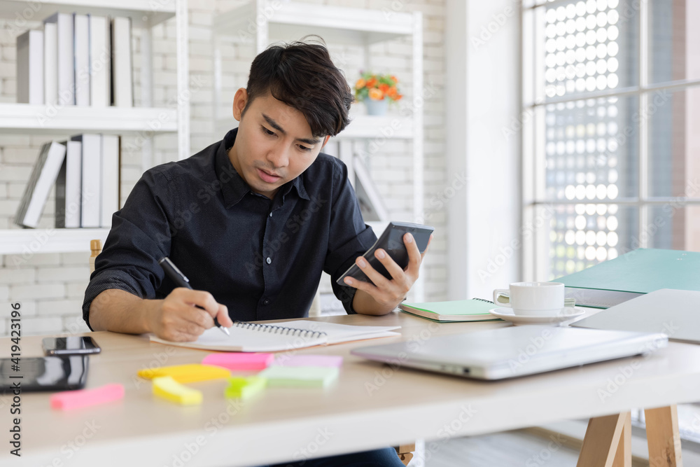 Yong Asian man having stressful time working from his home Yong Asian man having stressful time working from his home