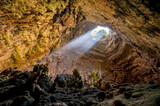 La Grave abyss of Grotte di Castellana with ray of sunlight in Puglia