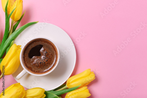 yellow tulips, a cup of black coffee on a pink background, a place for the inscription