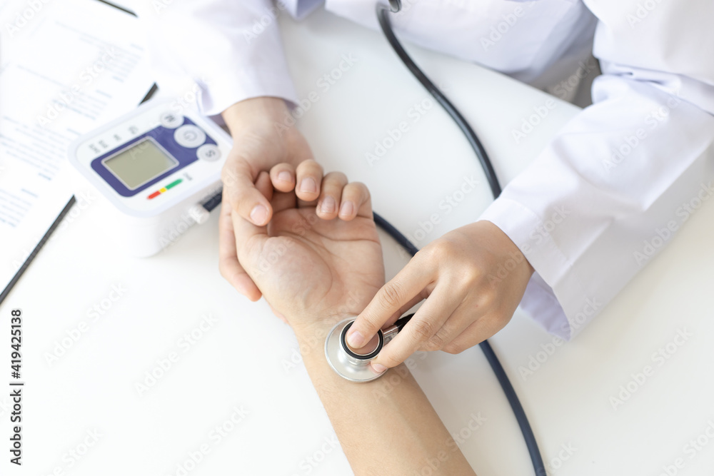 Female doctor uses a heart rate monitor of a male patient to take an initial pulse, Early health examination at a clinic or hospital. Female doctor uses a heart rate monitor of a male patient to take an initial pulse, Early health examination at a clinic or hospital.