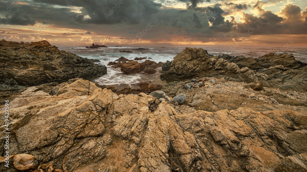 Obraz premium Beautiful seascape, ocean views, rocky coast, sunlight on the horizon. Composition of nature. Sunset scenery background. Cloudy sky. Water Reflection. California Seashore.