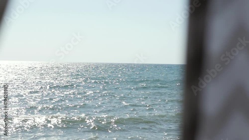 open curtains overlooking the sea. hotel overlooking the sea. hand opens the curtains