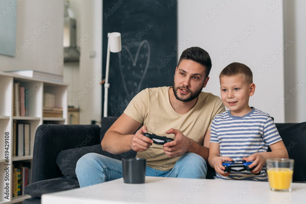 father play video games with his son at home father play video games with his son at home