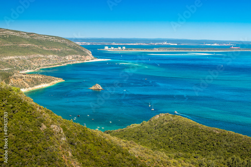 Beautiful landscape of the Arrábida Natural Park in Portugal, with the mountains, beaches, blue sea and in the background the Tróia peninsula on a sunny day in summer.