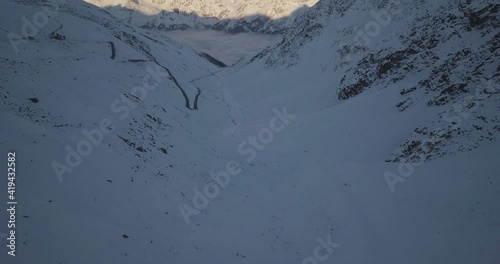 Aerial view of a road and a foggy valley, in the alps of Austria - tilt, drone shot photo