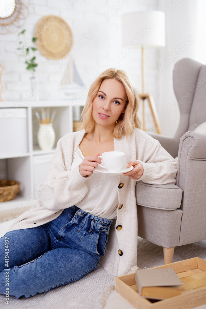 morning concept - portrait of cute blond woman drinking coffee in living room morning concept - portrait of cute blond woman drinking coffee in living room