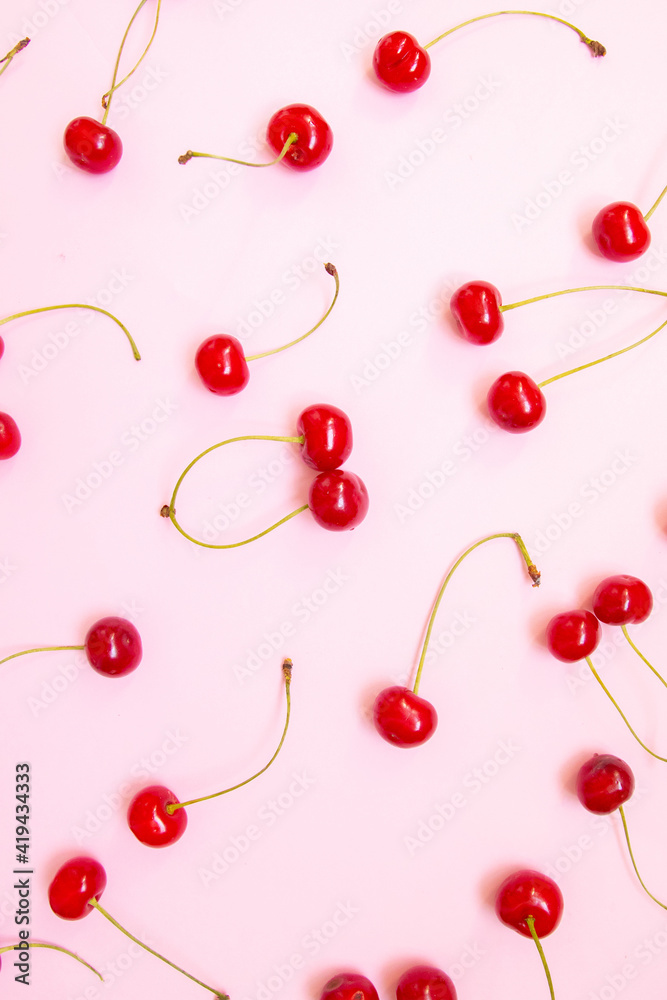 Big sweet cherry on a pink background. Top view, flat lay Big sweet cherry on a pink background. Top view, flat lay