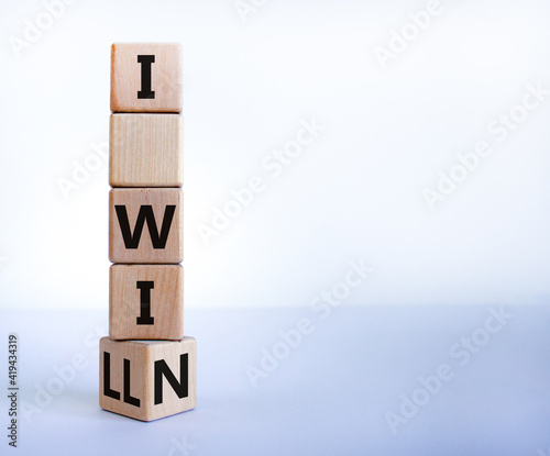 I will win symbol. Turned a wooden cube and changed words i will to i win. Beautiful white background, copy space. Business, motivational and i will win concept.