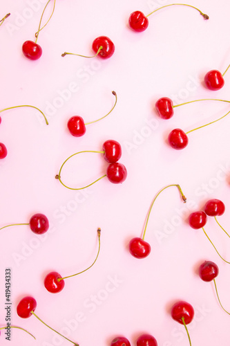 Big sweet cherry on a pink background. Top view, flat lay