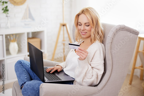 young beautiful woman using laptop and buying something in internet
