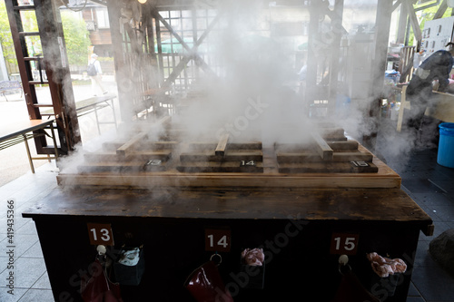 Traditional Japanese wooden Hot steam cooking, smoke from hot spring energy cooking  called Jigoku mushi kannawa , can steam many kind of food, vegetables, seafood, pork , at Beppu, Oita Japan. photo