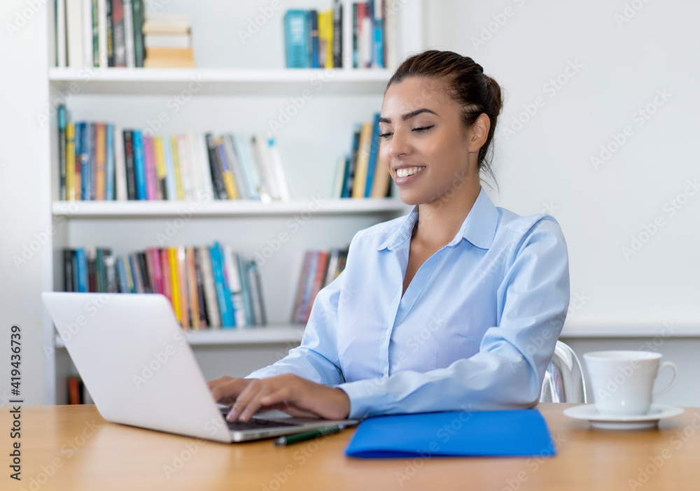 Beautiful latin american business trainee working at computer Beautiful latin american business trainee working at computer