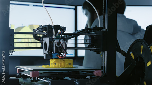 Obraz na płótnie 3d Printer printing yellow small house with engineer constructor in background at pc model